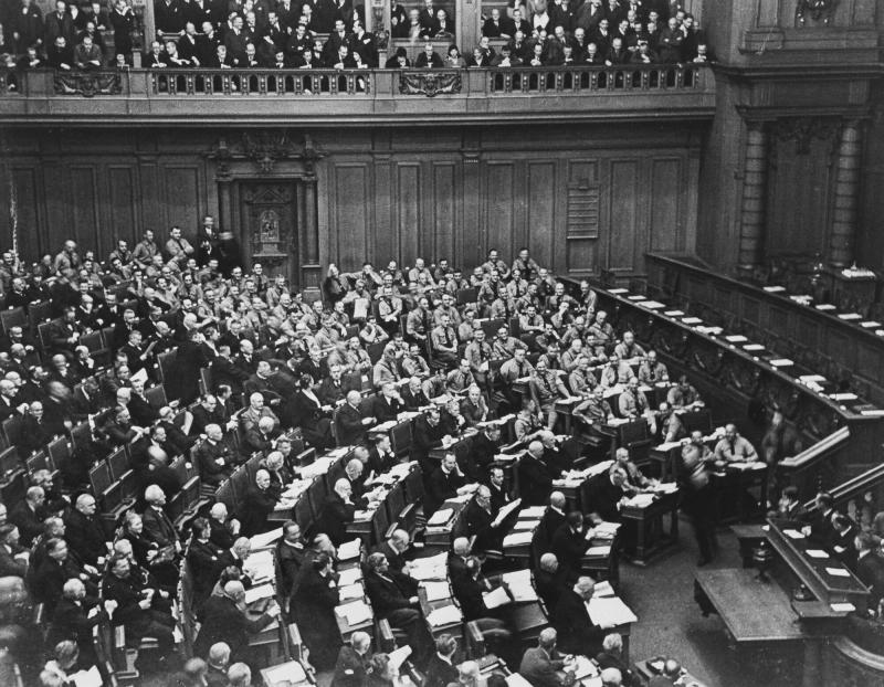 Nationalsocialisternas ledamöter har lämnat sessionen. Efter en stund återvänder nazisterna till sina platser, klädda i bruna skjortor, Berlin 1930