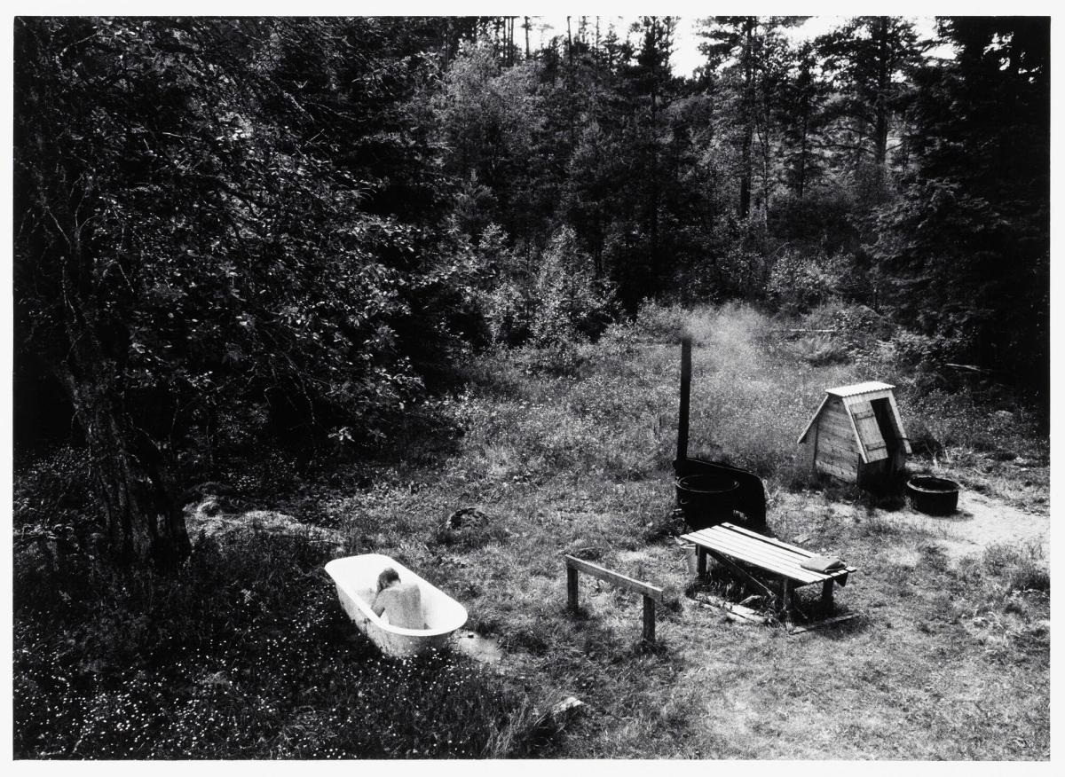 Gustav Karlsson på Skönstorp har värmt brunnsvatten och tar ett sommarbad bakom ladugården i sitt badkar med lejontassar. Ur serien Minnesbok över den svenske bonden