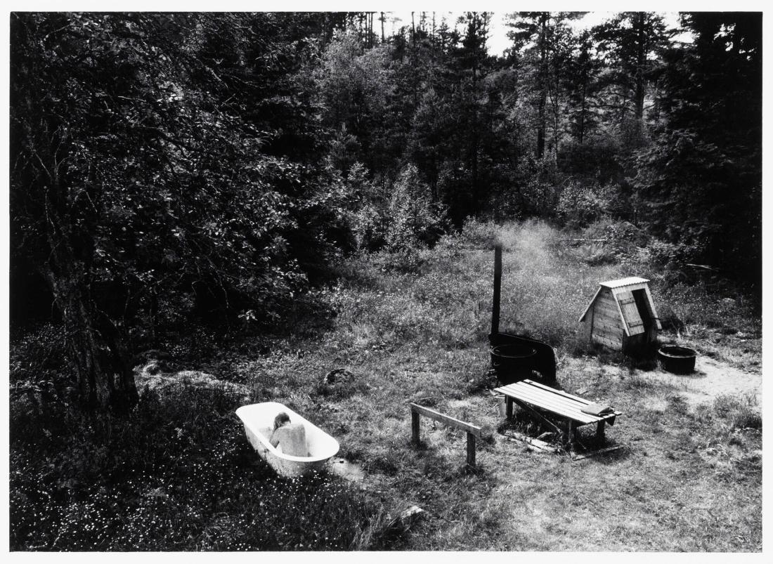 Gustav Karlsson på Skönstorp har värmt brunnsvatten och tar ett sommarbad bakom ladugården i sitt badkar med lejontassar. Ur serien Minnesbok över den svenske bonden