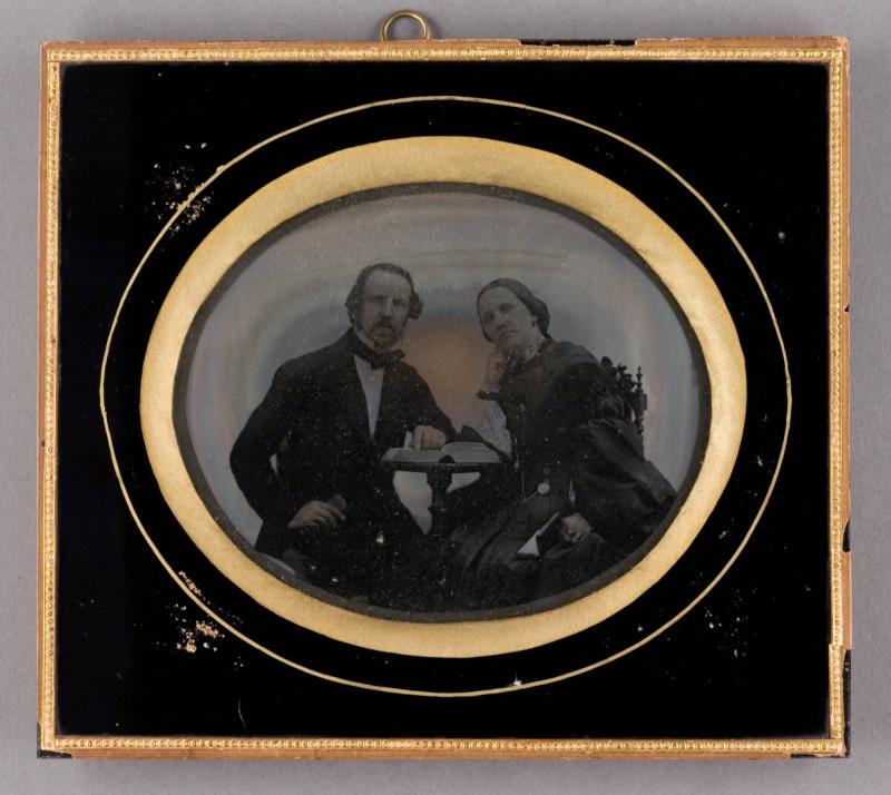 Porträtt av man och kvinna sittande vid bord