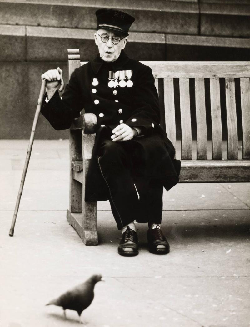 En gammal ärevördig soldat, 'Chelsea Pensioner', sittandes bland mångfaldet duvor på 'Trafalgar Square'