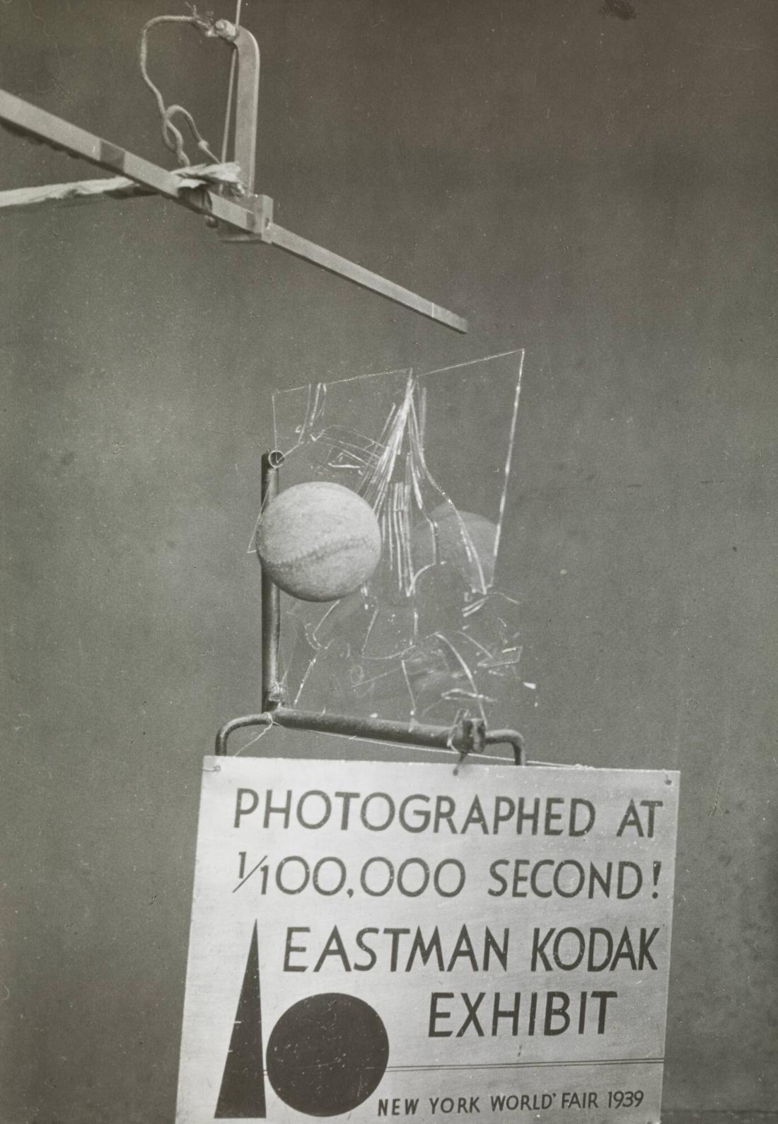 En träkula krossar en glasskiva. Kodak