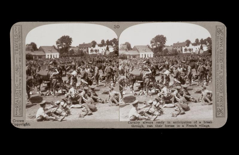 Cavalry always ready in anticipation of a breakthrough, rest their horses in a French village. From the box The Great War