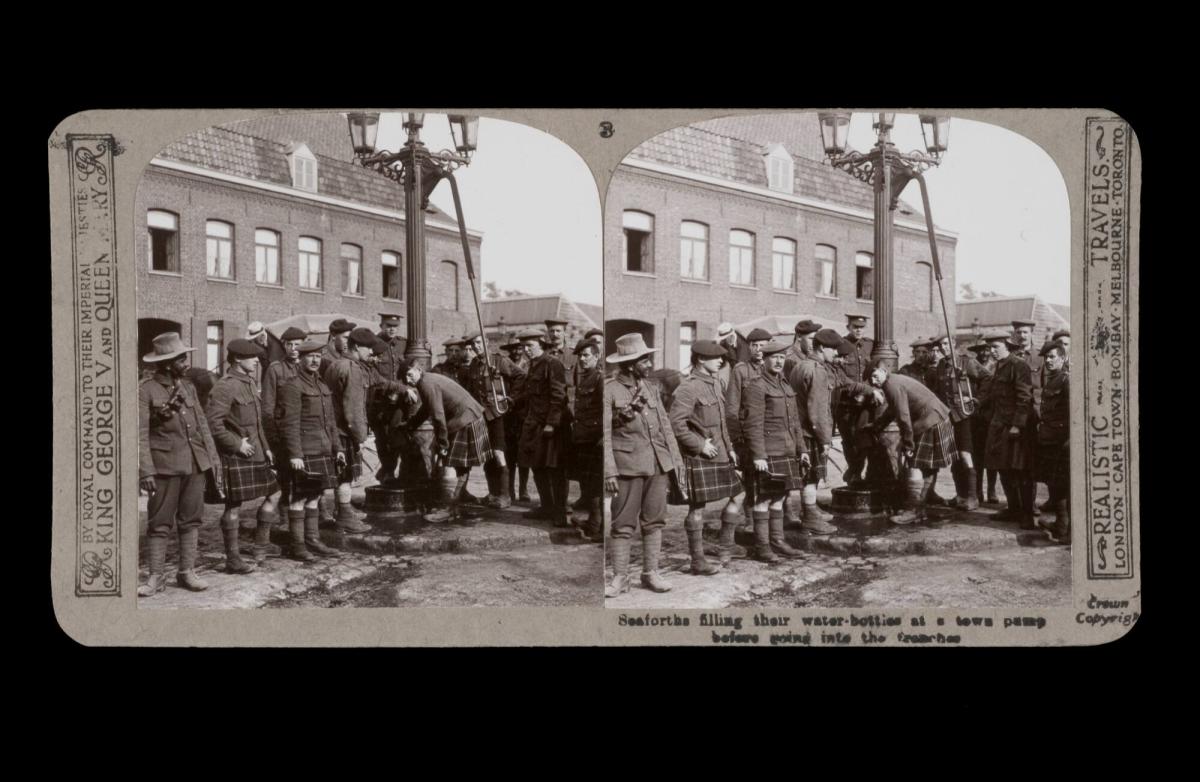 Seaforths filling their water-bottles at a town pump before going into the trenches. 
From the box The Great War