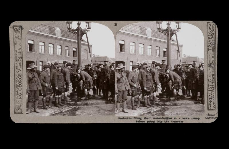Seaforths filling their water-bottles at a town pump before going into the trenches. 
From the box The Great War